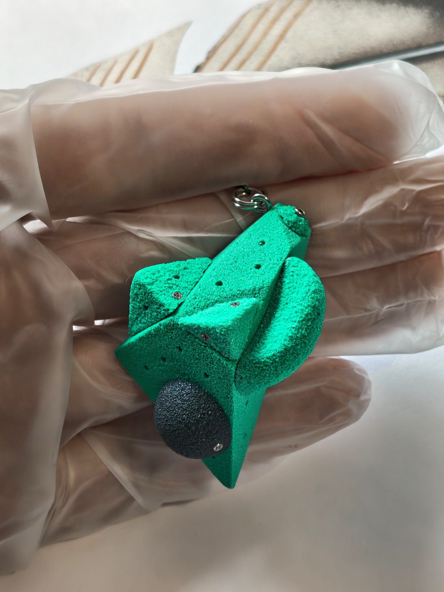 Green miniature climbing volume with dark rounded hold