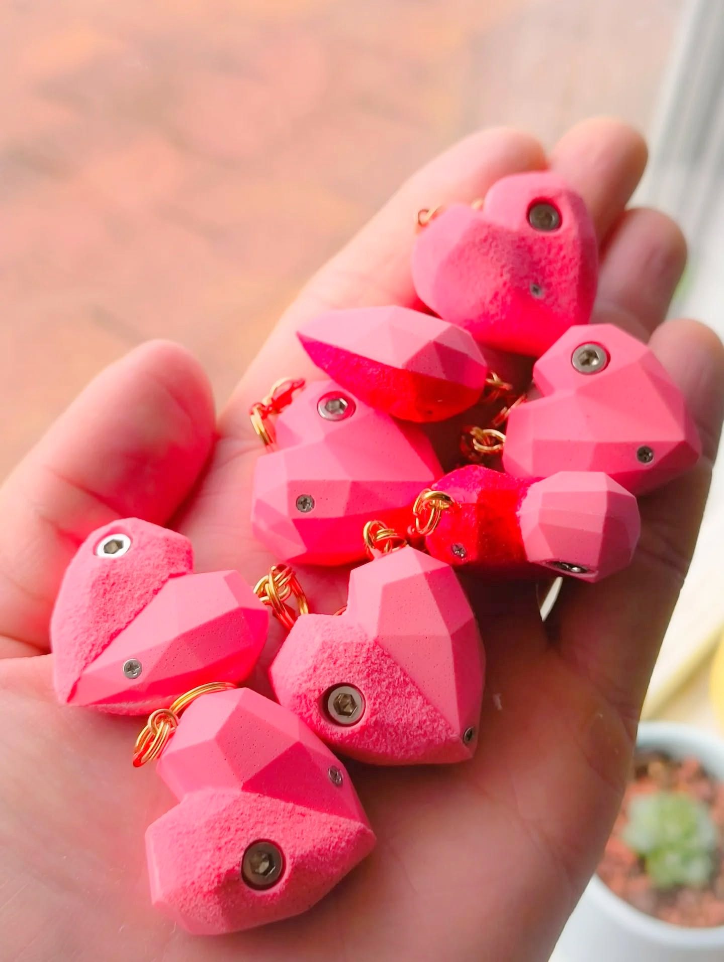 Collection of pink heart-shaped climbing hold keychains