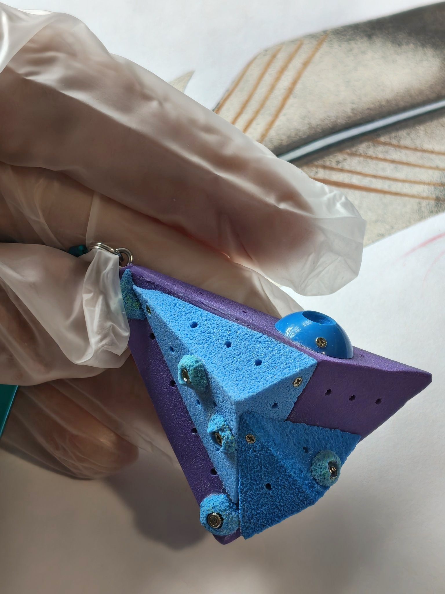 Side view of blue and purple triangular climbing piece